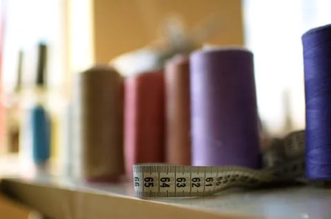 A few reels of sewing thread of different colors on the table Stock Photos
