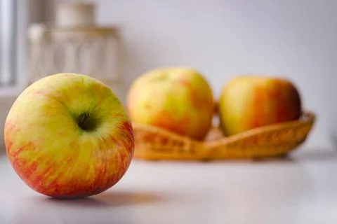 A few ripe apples on a white surface. Rear background is blurred Stock Photos