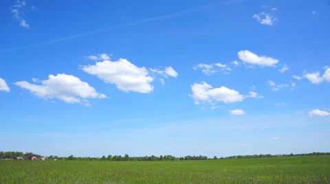 A few small clouds over the green field. Timelapse Stock Footage 50876824
