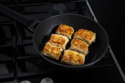 Few stuffed cabbage rolls fried on frying pan Stock Photos