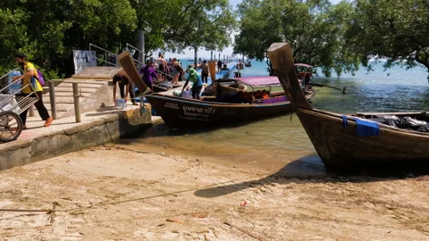 Few Thai young men unloading soft drinks and water packages from boat Stock Footage 203895526