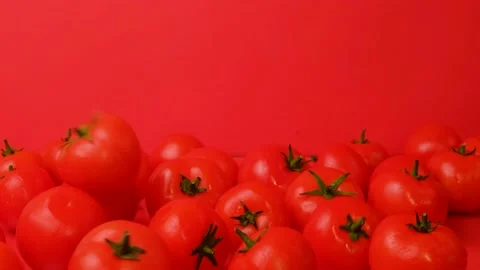 A few tomatoes fall on a pile of vegetables on a red background. A tomatoes fall Stock-Footage 152192604