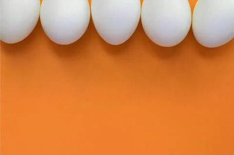 A few white easter eggs on a bright orange background Foto stock