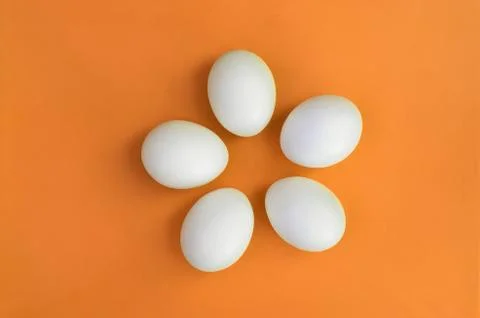 A few white easter eggs on a bright orange background Stock Photos