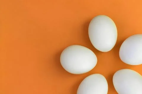 A few white easter eggs on a bright orange background 库存照片