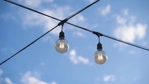 FHD Decorative lights on wire with blue sky and clouds Stock Footage 235025228