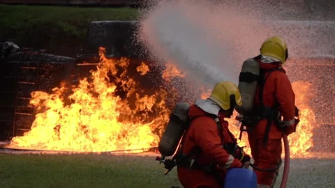 FHD Slow motion: Firefighter using Chemical foam fire extinguisher to fightin Stock Footage
