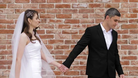 Fiance looks at long haired bride with veil and smiles Stock Footage 131045442