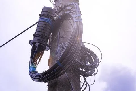 A fiber optic cable harness for communication weighs on a concrete column. .. Stock Photos