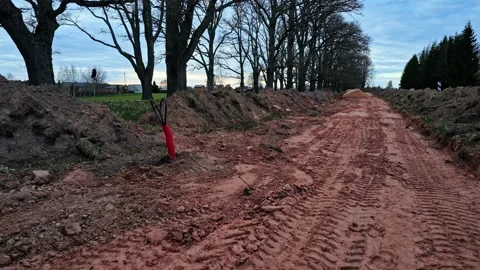 Fiber optic cable installation site along muddy rural road construction Vídeos de archivo 336697375