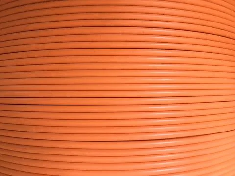 Fiber optic cables are arranged in rolls orange background Stock Photos