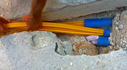 Fiber optic cables buried in a micro trench by a worker Stock Photos