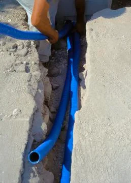 Fiber optic cables buried in a micro trench by a worker Stock Photos