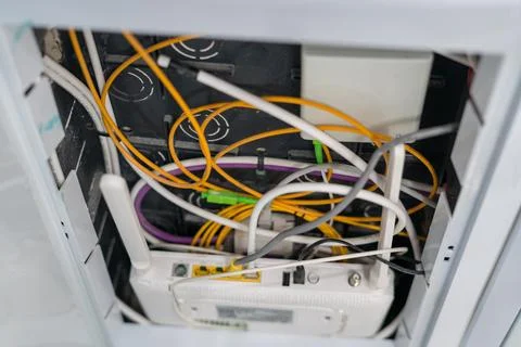 Fiber optic cables connected to internet router in wall box 스톡 사진