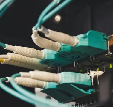 Fiber Optic Cables Connected to Network Equipment in Data Center Stock Photos