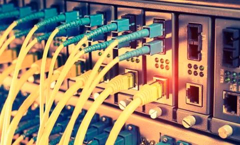 Fiber Optic cables connected to an optic ports and Network cables connected t Stock Photos