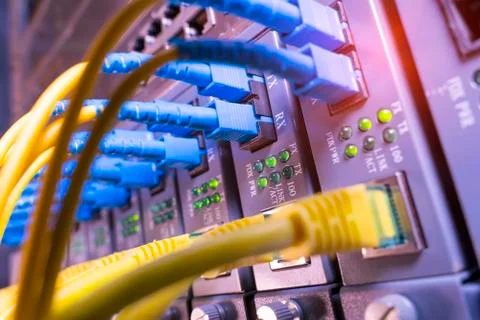 Fiber Optic cables connected to an optic ports and Network cables connected t Stock Photos