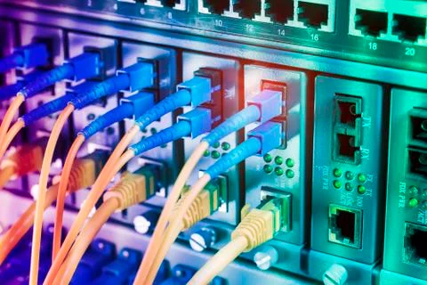 Fiber Optic cables connected to an optic ports and Network cables connected t Stock Photos