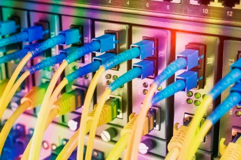 Fiber Optic cables connected to an optic ports and Network cables connected t Foto stock