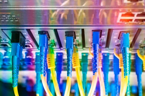 Fiber Optic cables connected to an optic ports and Network cables connected t Stock Photos