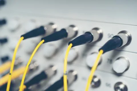 Fiber Optic cables connected to an optic ports and Network cable system Stock Photos