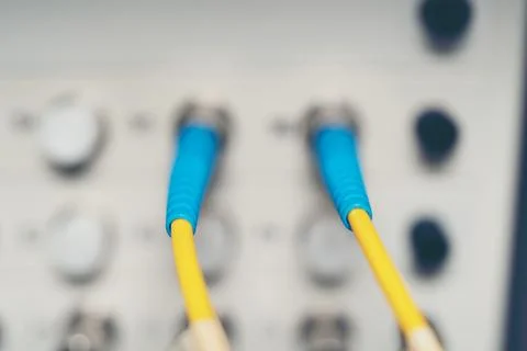 Fiber Optic cables connected to an optic ports and Network cable system Stock Photos