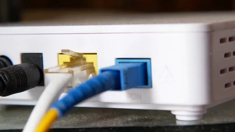 Fiber optic internet connection plugged into a router on a desk. Stock Footage 333158734