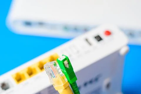 Fiber optical and network cables with internet wireless router on a blue ba.. Stock Photos