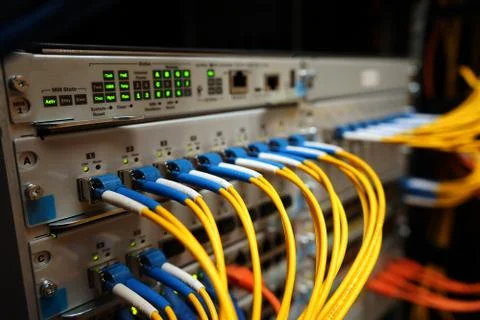 Fibre cables going in to a network switch Stock Photos