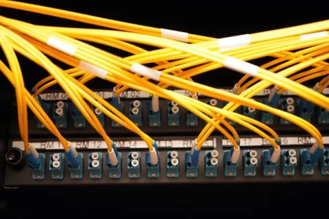 Fibre cables going in to a patch panel Stock Photos