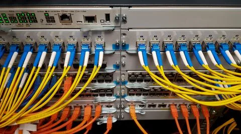 Fibre optic cables going in to a network switch Stock Photos