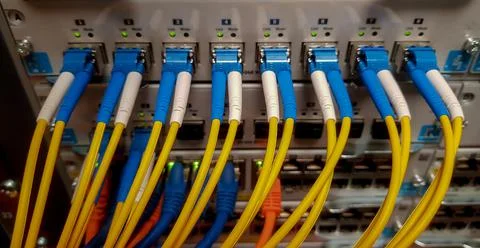 Fibre optic cables going in to a network switch Stock Photos