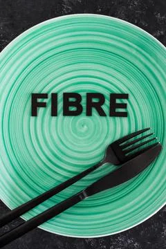 Fibre (uk spelling) text on dining plate with fork and knife, healthy nutriti Stock Photos