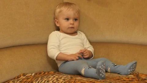 Fidget cute 9-10 months old baby boy motion on sofa Stock Footage 82614629