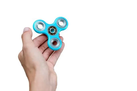 Fidget spinner. Blue hand spinner, fidgeting hand toy rotating on child's han Stock Photos