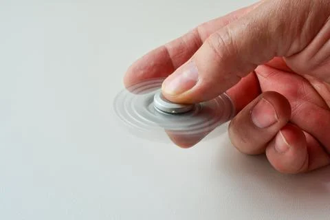 Fidget spinner in motion, side view Stock Photos