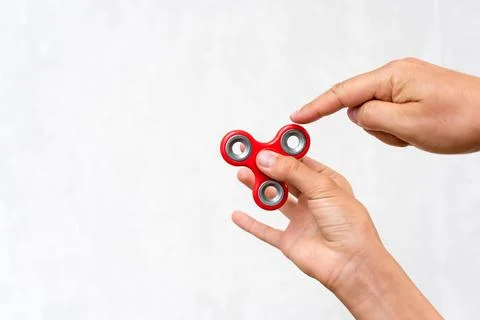 Fidget spinner. Red hand spinner, boys playing with fidgeting hand toy. Stres Stock Photos