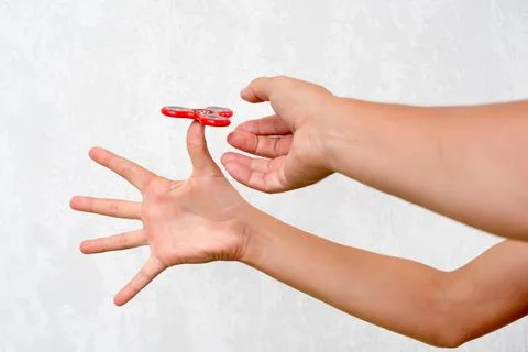 Fidget spinner. Red hand spinner, boys playing with fidgeting hand toy. Stres Stock Photos