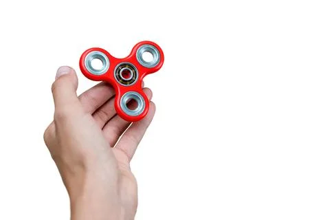 Fidget spinner. Red hand spinner, fidgeting hand toy rotating on child's hand Stock Photos
