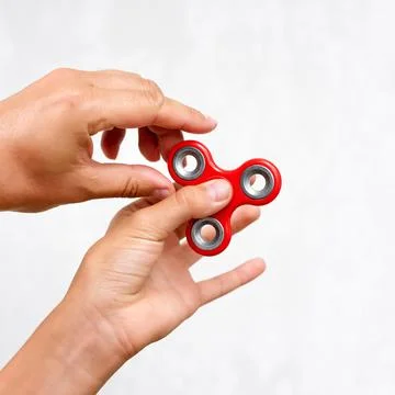 Fidget spinner. Red hand spinner, boys playing with fidgeting hand toy. Stres Stock Photos