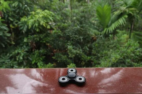 A fidget spinner resting on an open space Stock Photos