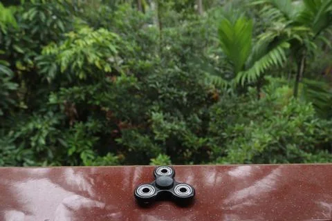 A fidget spinner resting on an open space Stock Photos