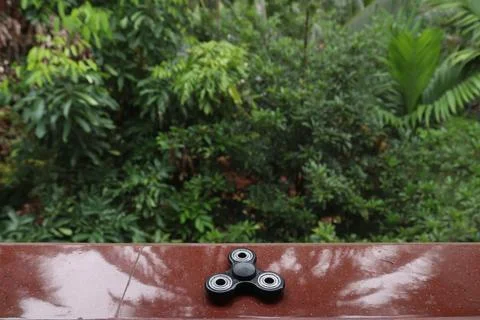 A fidget spinner resting on an open space Stock Photos