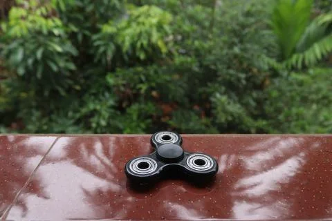 A fidget spinner resting on an open space Stock Photos