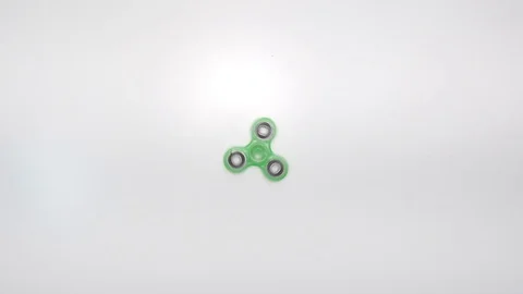 Fidget Spinner Spinning on table overhead shot Stock Footage 100645683