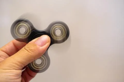 Fidget spinner turning in man hand with motion blur close up view Foto stock