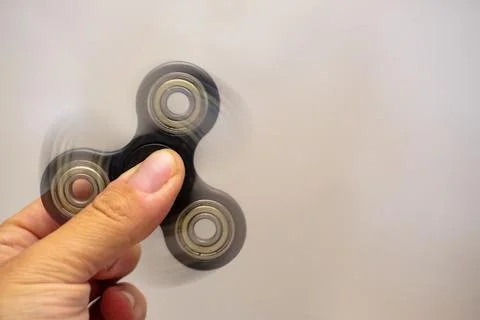 Fidget spinner turning in man hand with motion blur close up view Foto stock