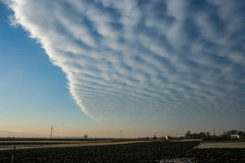 Field of altocumulus clouds with a sharp edge is invading the sky Stock Photos