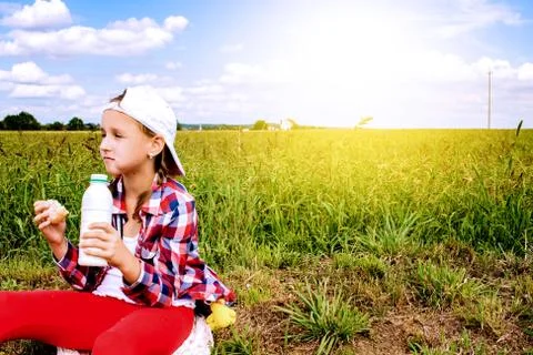In the field the child eats Stock Photos