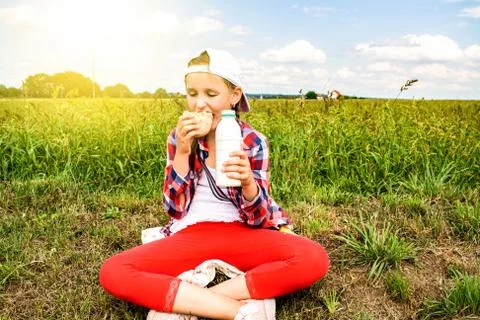 In the field the child eats Stock Photos